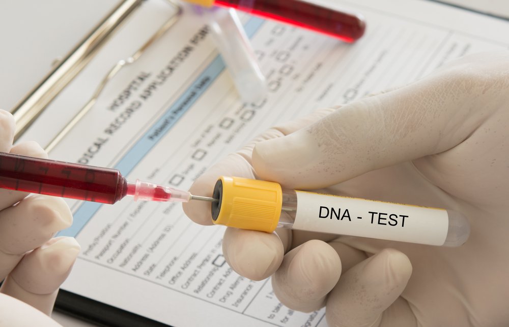 el médico utiliza una jeringa para introducir una muestra de sangre en un tubo de ensayo de adn en el laboratorio